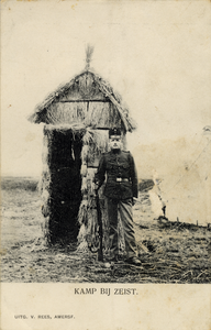 16163 Afbeelding van een op wacht staande militair bij een strohut in het Kamp van Zeist te Zeist.